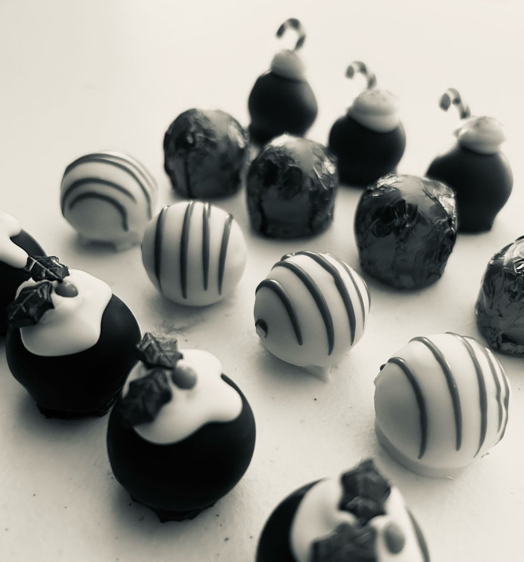 Black-and-white photo of Christmas chocolates with candy cane decorations, striped shells and foil-wrapped pieces